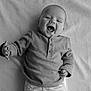 baby, infant, smile, laughing, black_and_white, portrait, clothing, long_sleeve, blanket, texture, hand, face, happy, cute, young_child, lying_down, expression, child, one_person, indoors