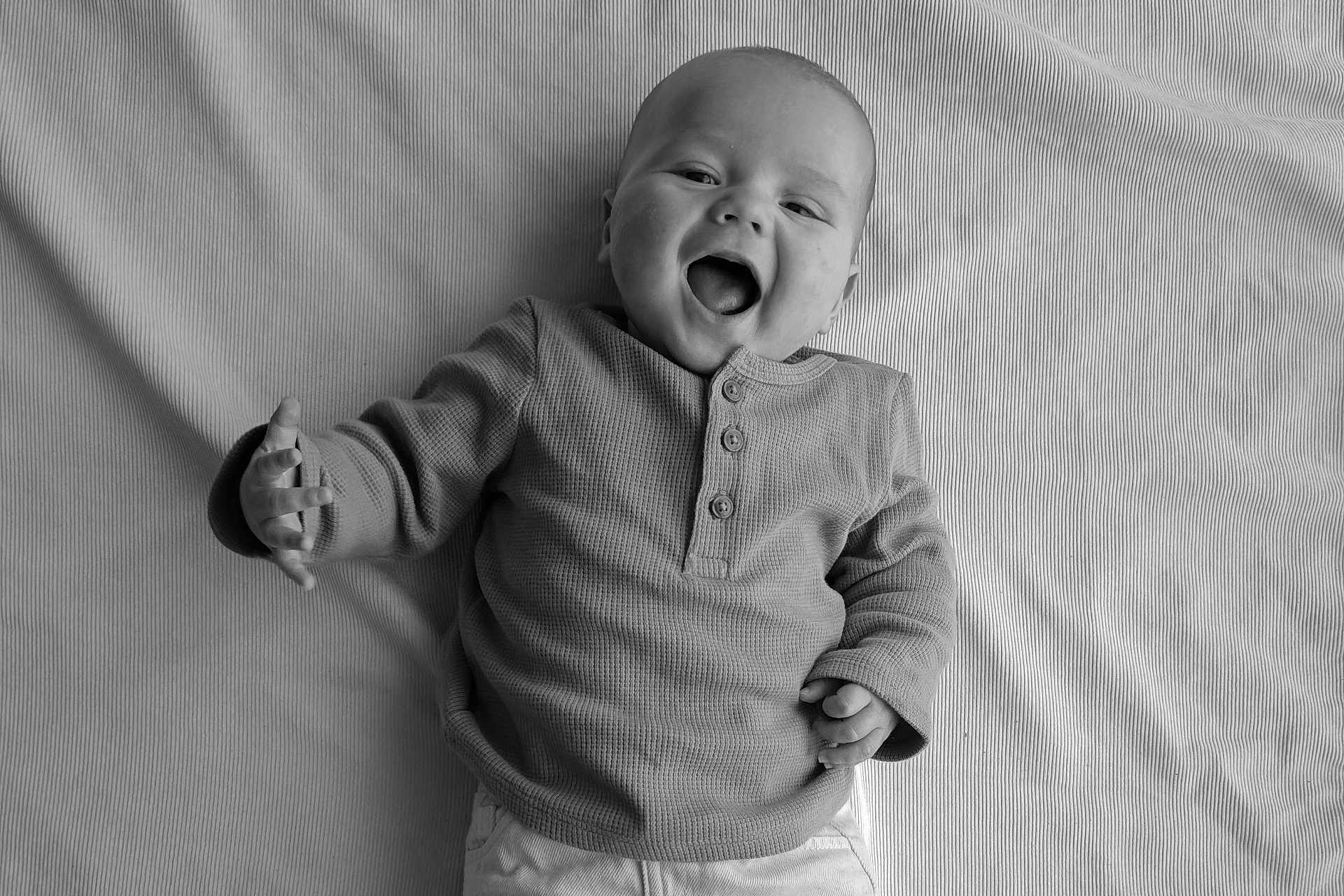 Hélio participe au concours pour gagner de l'argent avec cette photo : baby, infant, smile, laughing, black_and_white, portrait, clothing, long_sleeve, blanket, texture, hand, face, happy, cute, young_child, lying_down, expression, child, one_person, indoors