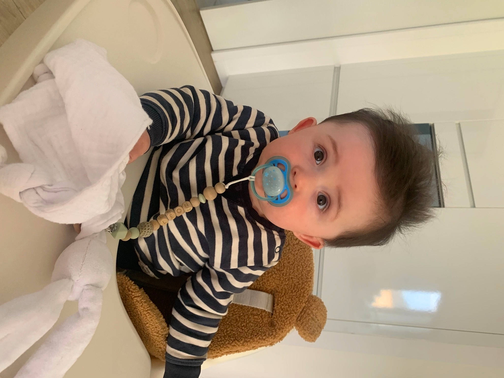 Léon participe au concours pour gagner de l'argent avec cette photo : baby, baby_toddler_clothing, cheek, child, comfort, elbow, eye, eyelash, flooring, human_body, human_leg, knee, leg, neck, person, room, shoulder, sleeve, surprise, thigh