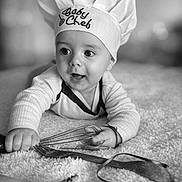 Ugo participe au concours pour gagner de l'argent avec cette photo : baby, chef_hat, whisk, banana, kitchen_utensils, black_and_white, portrait, infant, cute, curious, soft_texture, laying_down, cooking_theme, headwear, child, monochrome, expression, indoors, small_person, baby_chef