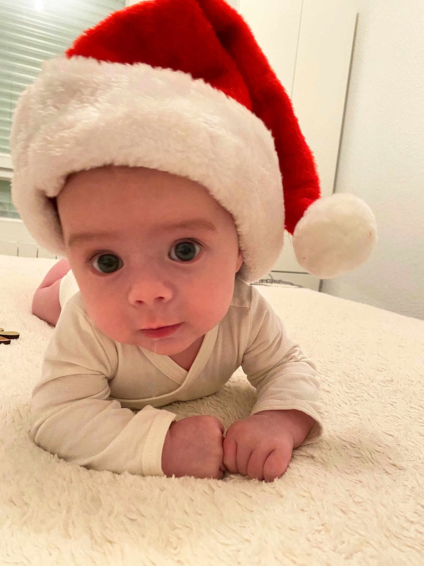 Ugo participe au concours pour gagner de l'argent avec cette photo : baby, infant, santa_hat, holiday, cute, soft_blanket, indoors, child, face, wide_eyes, white_clothing, portrait, close_up, festive, christmas, smiling, young_child, resting, cozy, cute_expression