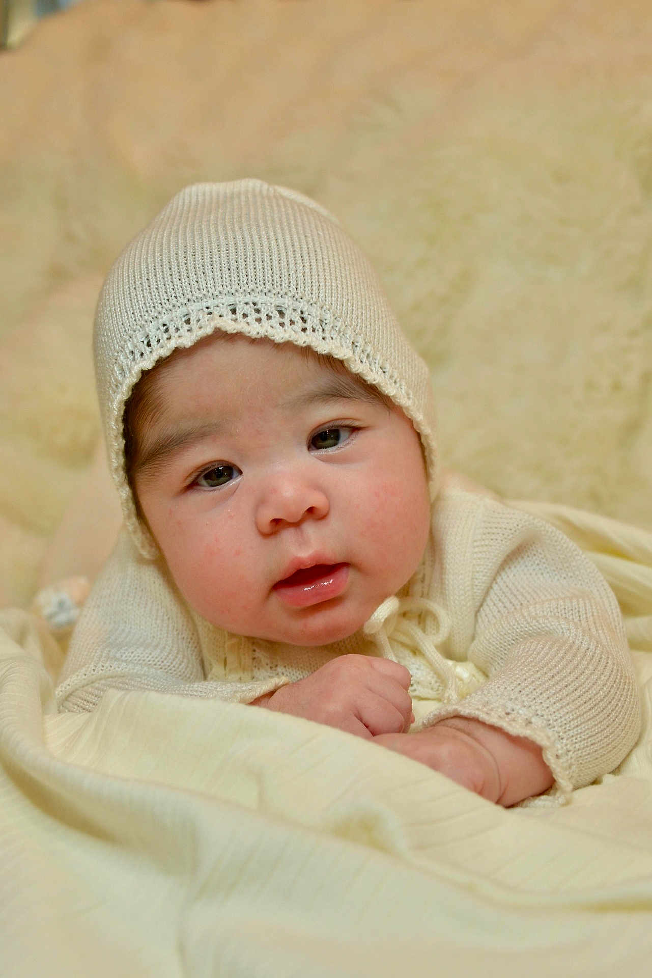 Darla joined the competition — help win amazing prizes! baby, infant, knit_hat, bonnet, blanket, soft_texture, close_up, portrait, cheeks, eyes, mouth, hands, cozy, indoor, cream_color, laying_down, cute, newborn, clothing, studio_style