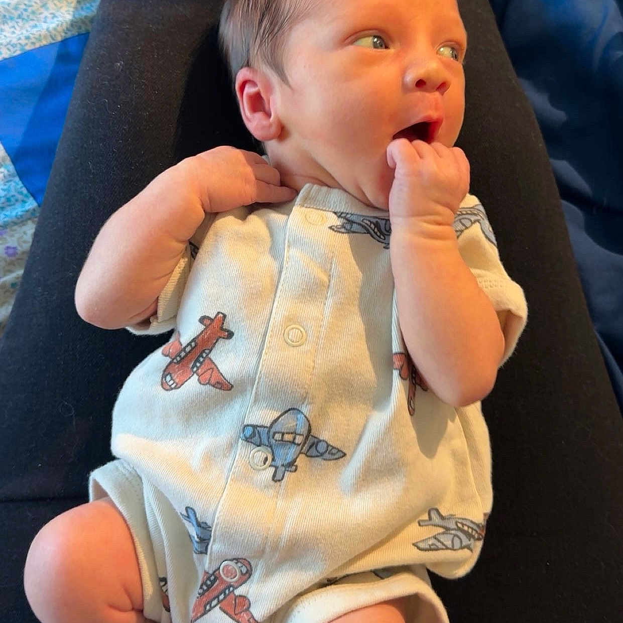 Creighton joined the competition — help win amazing prizes! airplane, baby, bed, blue, clothing, curious, cute, expression, face, hand, infant, legs, lying, newborn, onesie, pattern, person, skin, sleepwear, socks