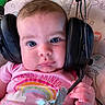 baby, headphones, pink_shirt, rainbow, microphone, child, face, expression, curious, animal_pattern, background, hand, clothing, infant, cute, indoor, portrait, closeup, person, technology