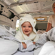 Rory is registered to the contest to win money with this photo: baby, child, smile, hoodie, knitwear, blanket, bed, van, interior, person, happy, cute, cozy, white, face, portrait, indoor, travel, comfort, candid