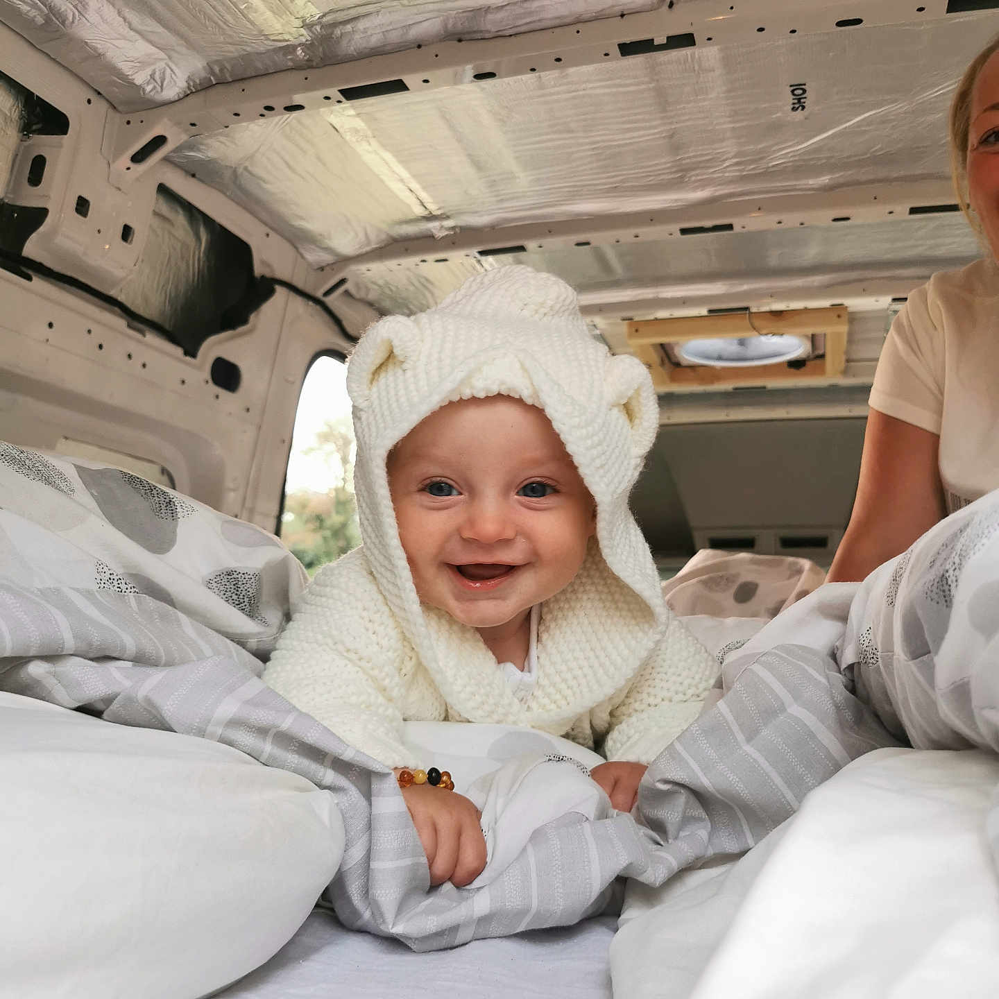 Rory is registered to the contest to win money with this photo: baby, bed, blanket, candid, child, comfort, cozy, cute, face, happy, hoodie, indoor, interior, knitwear, person, portrait, smile, travel, van, white