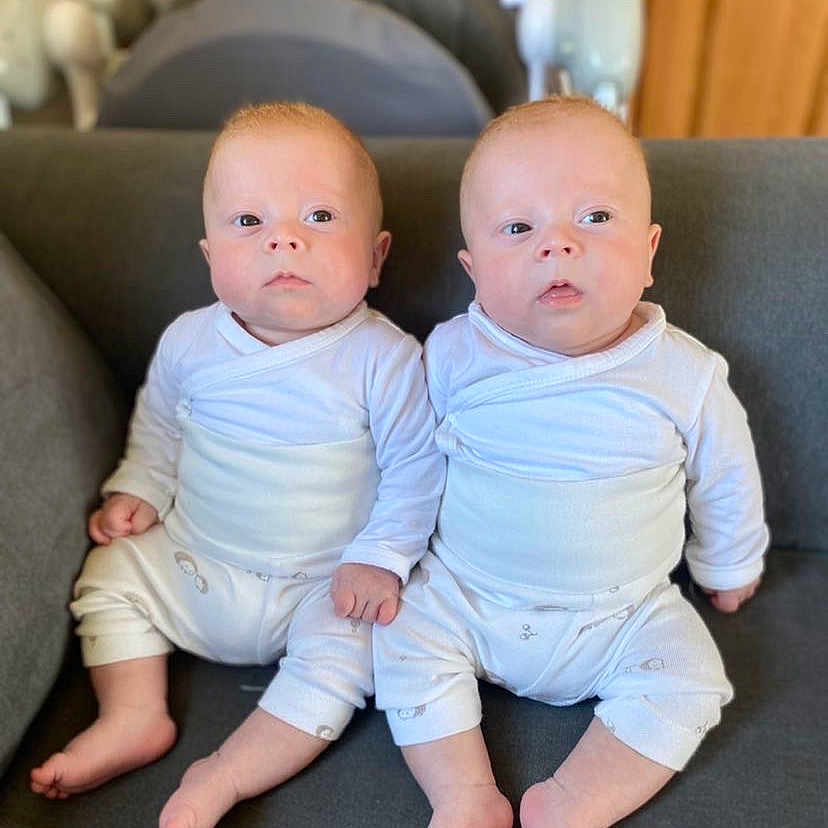 Swayver Et Swayze a rejoint le concours — aidez-le/la à gagner de superbes lots ! baby, child, couch, cute, expression, face, footwear_none, furniture, home, indoor, infant, person, relaxation, sitting, skin, soft_lighting, twins, two_people, white_clothing, young_child