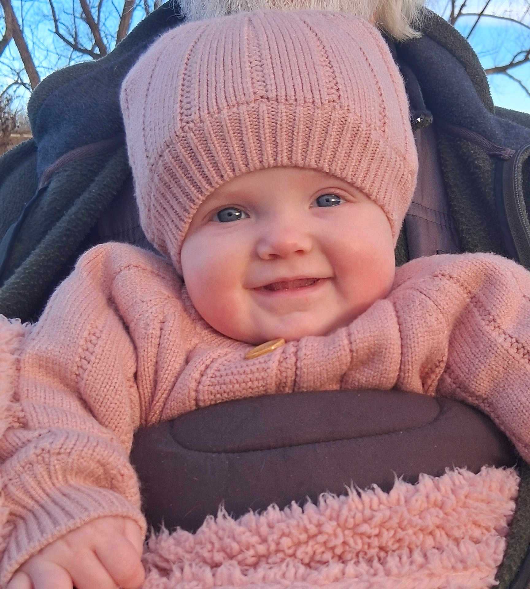 Taytum joined the competition — help win amazing prizes! baby, child, smile, hat, knitwear, sweater, outdoor, winter_clothing, blue_eyes, cheeks, person, portrait, happy, cozy, bundle, nature, trees, daylight, face, cute