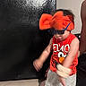 child, toddler, elmo, sunglasses, headband, orange, red, tank_top, shorts, indoor, tile_floor, person, motion_blur, black_door, playful, fun, accessories, cute, expression, home