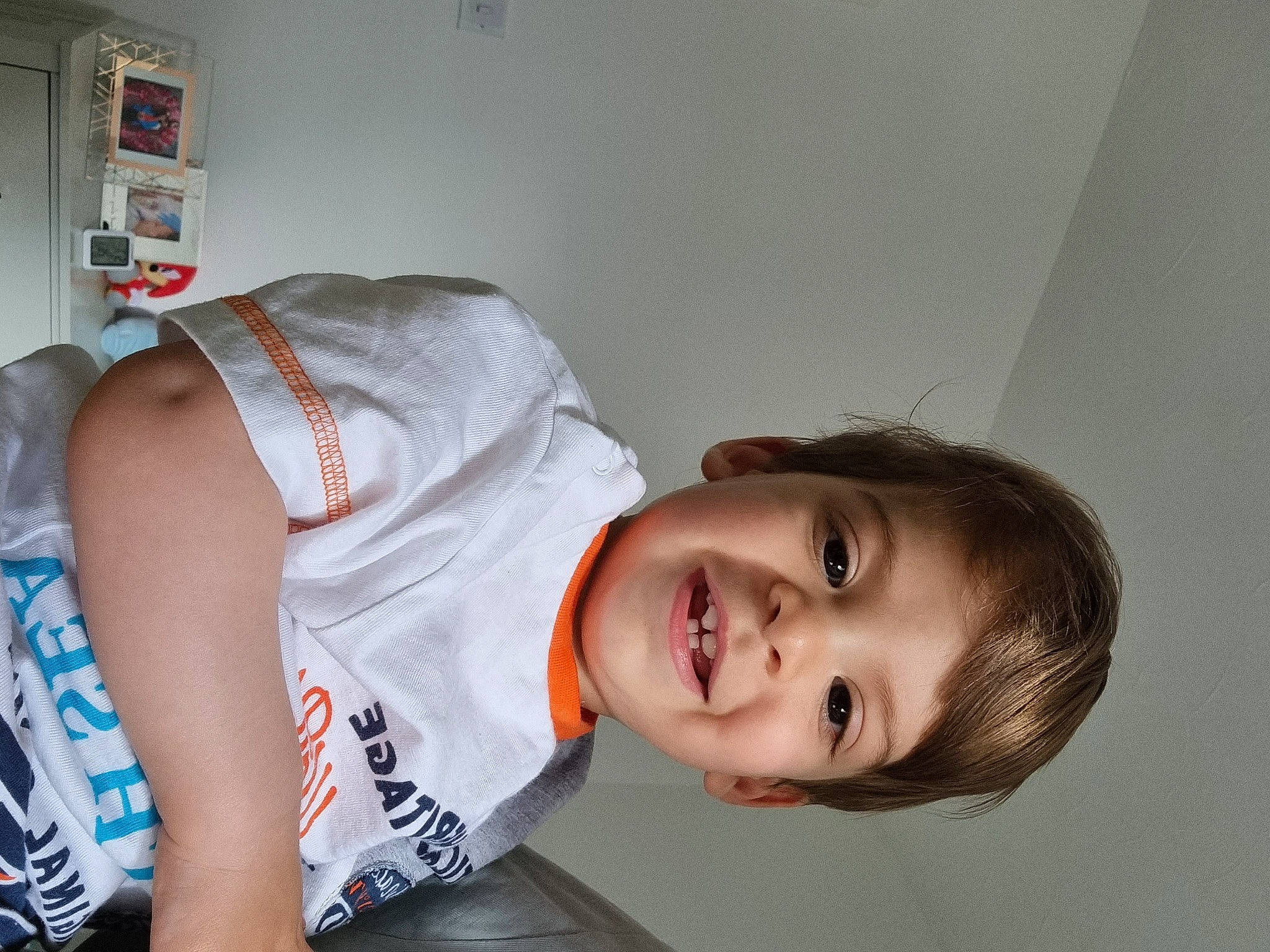 Dominic is registered to the contest to win money with this photo: abdomen, baby_toddler_clothing, child, comfort, elbow, flash_photography, fun, happy, human_leg, joy, knee, mouth, person, room, shoulder, sitting, sleeve, smile, t_shirt, thigh