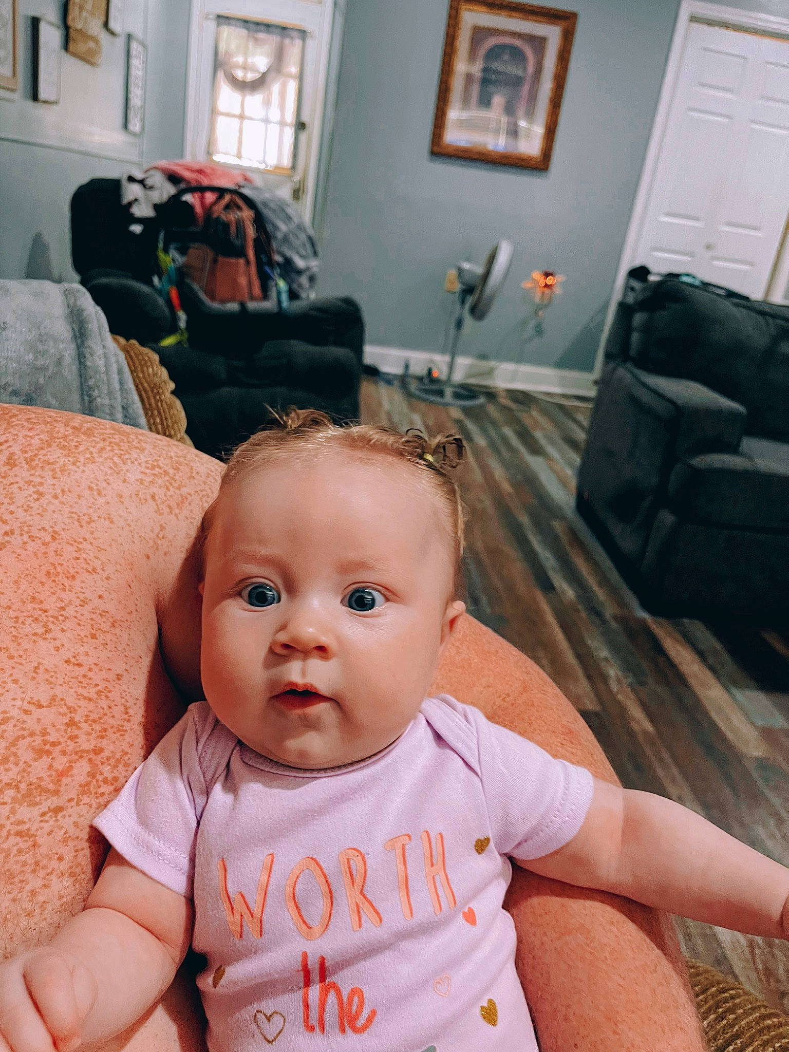 Oakleigh is registered to the contest to win money with this photo: baby, baby_toddler_clothing, cheek, chin, comfort, couch, eye, eyebrow, face, floor, flooring, head, iris, lip, mouth, person, picture_frame, skin, smile, surprise