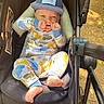 Leo is registered to the contest to win money with this photo: baby, child, stroller, cap, pajamas, footwear, outdoor, sunlight, playful, smiling, infant, seat, baby_clothing, baby_gear, person, happy, nature, daylight, cute, relaxing