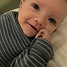baby, blanket, blue_clothing, child, cute, eyes, face, hand, happy, indoors, infant, lying_down, mouth, person, portrait, skin, smiling, soft, striped_clothing, young