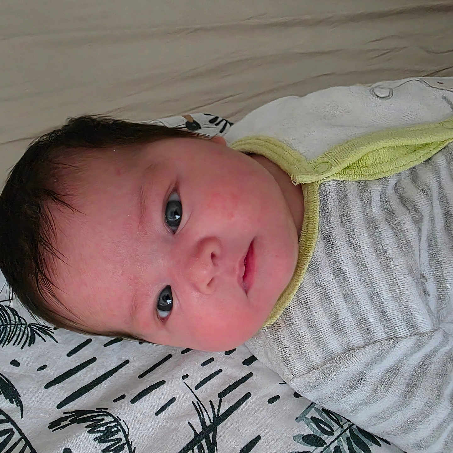 Amelia participe au concours pour gagner de l'argent avec cette photo : baby, blanket, blue_eyes, cheeks, closeup, curious, expression, face, hair, head, indoor, infant, lying_down, onesie, pattern, resting, skin, soft_light, striped_clothing, young_child