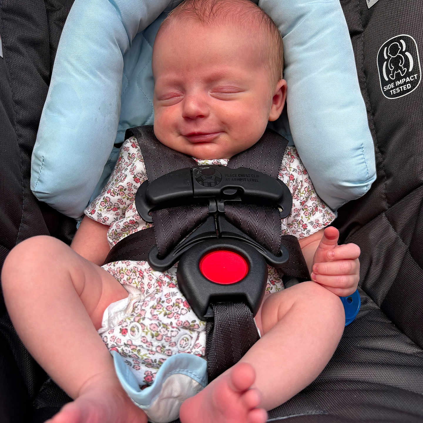 Raylee joined the competition — help win amazing prizes! baby, infant, car_seat, child, smiling, face, headrest, safety_harness, clothing, onesie, floral_pattern, feet, hands, sleepy, comfort, seat, baby_accessory, cute, peaceful, portrait