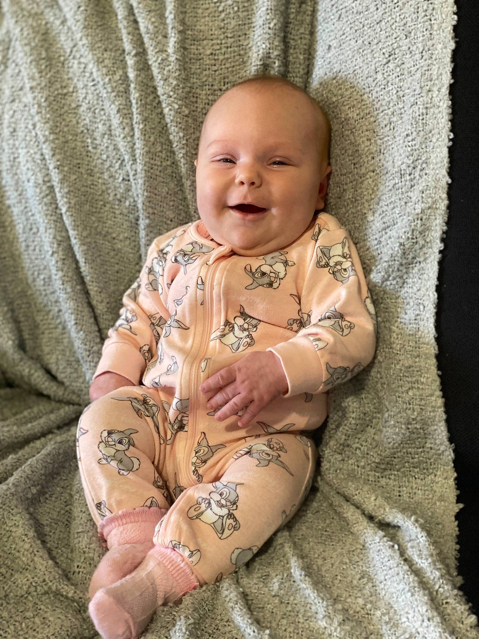 Winter is registered to the contest to win money with this photo: baby, baby_toddler_clothing, cheek, chest, child, comfort, elbow, eye, flash_photography, happy, human_leg, linens, pattern, person, sitting, skin, sleeve, smile, stomach, textile