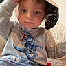 Victor a rejoint le concours — aidez-le/la à gagner de superbes lots ! toddler, child, sweatshirt, dinosaur, jeans, hat, indoor, couch, quilted, casual_clothing, person, cute, young_child, playful, sitting, portrait, face, expression, hand, light