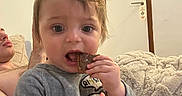 Victor a rejoint le concours — aidez-le/la à gagner de superbes lots ! toddler, child, snack, cookie, chocolate, indoor, couch, blanket, person, relaxing, adult, hair, clothing, hand, face, eyes, mouth, cozy, living_room, casual