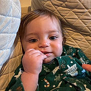 Victor participe au concours pour gagner de l'argent avec cette photo : baby, child, face, hand, couch, quilted_cushion, green_clothing, holiday_theme, indoor, portrait, cute, infant, smiling, cozy, closeup, fingers, person, young_child, skin, expression
