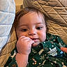baby, child, face, hand, couch, quilted_cushion, green_clothing, holiday_theme, indoor, portrait, cute, infant, smiling, cozy, closeup, fingers, person, young_child, skin, expression