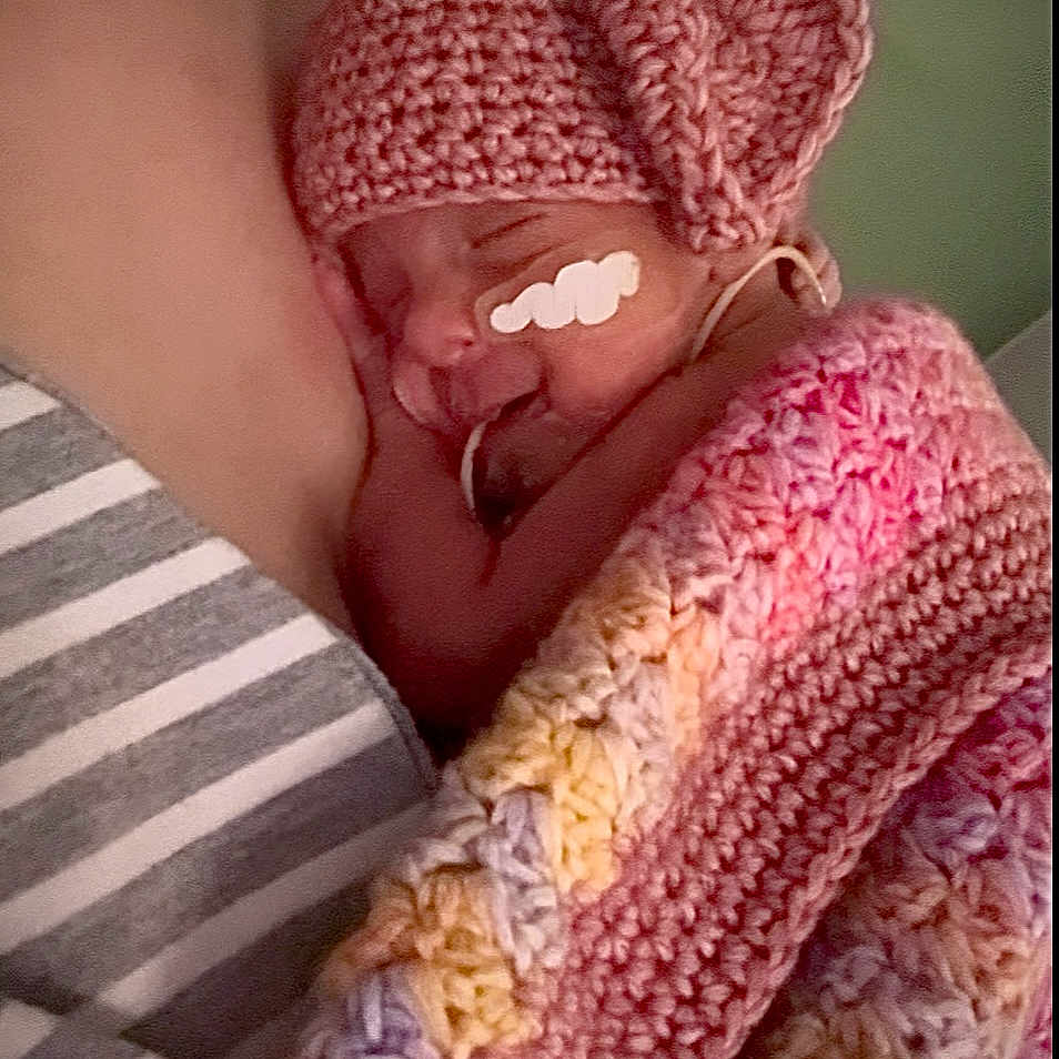Naela is registered to the contest to win money with this photo: baby, blanket, child, closeup, cozy, crocheted, cute, face, hat, infant, newborn, person, pink, resting, skin, sleeping, snuggled, soft, striped_shirt, warm