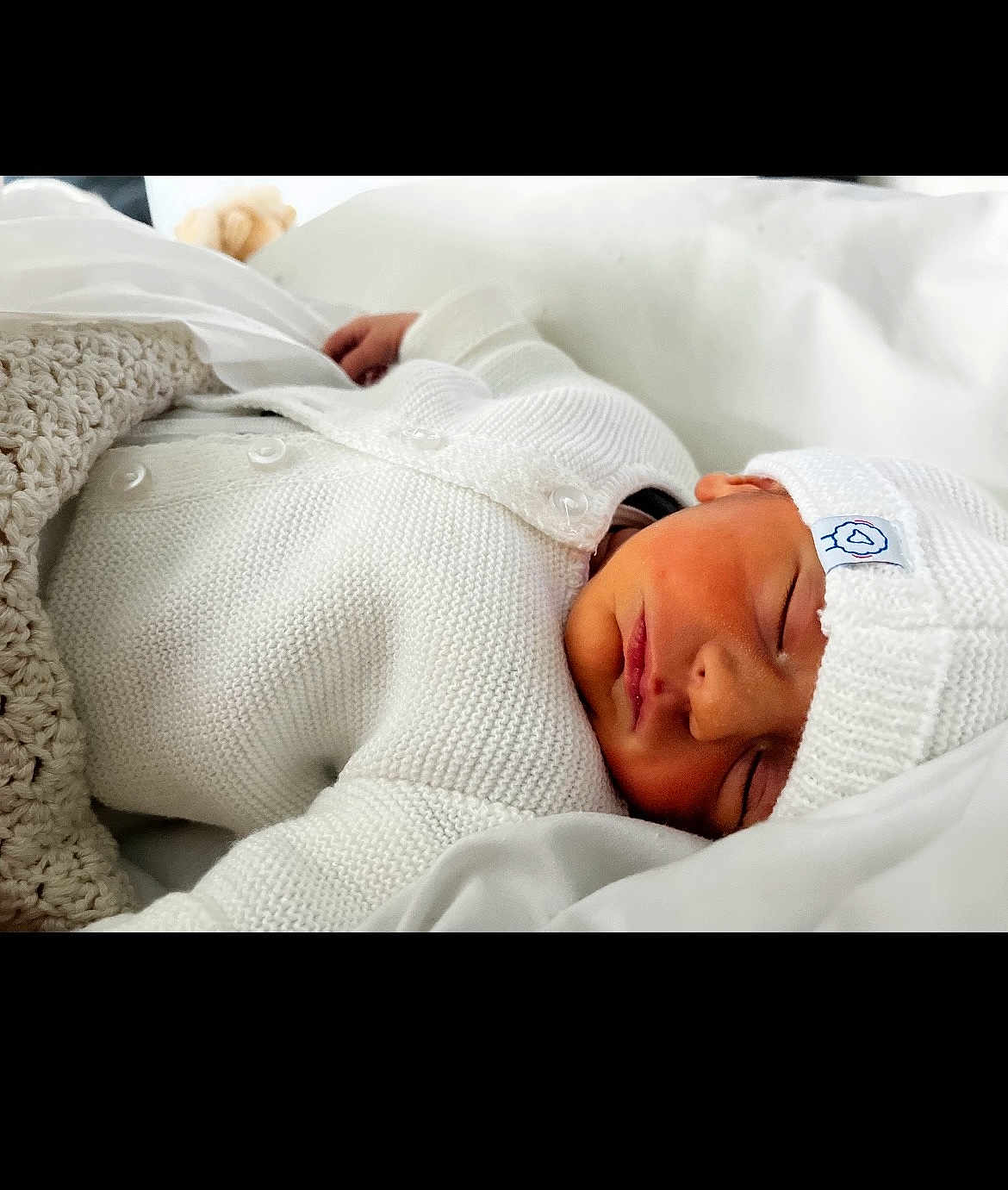 Swann a rejoint le concours — aidez-le/la à gagner de superbes lots ! newborn, baby, sleeping, white_clothing, knitwear, hat, blanket, soft, peaceful, infant, cute, resting, portrait, indoors, closeup, cozy, child, person, warm, comfort