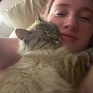 Lady is registered to the contest to win money with this photo: affection, cat, closeup, comfort, companion, cozy, cuddle, cute, face, fluffy_cat, home, indoor, person, pet, pillow, relaxation, sleepy, snuggle, soft_light, warm