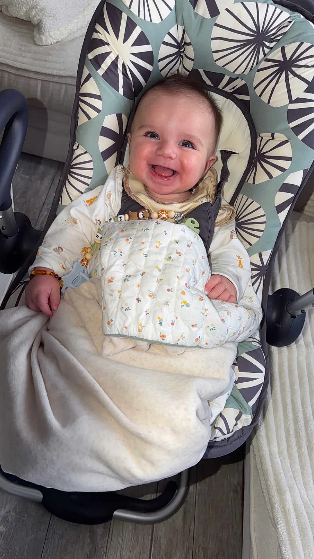 Igor participe au concours pour gagner de l'argent avec cette photo : baby, smiling, blanket, baby_rocker, infant, happy, indoors, cozy, child, face, clothing, pattern, flooring, home, comfort, seated, toy, wood_floor, furniture, cute