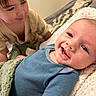Kendall is registered to the contest to win money with this photo: baby, toddler, child, smile, face, blanket, blue_shirt, yellow_shirt, indoor, bed, curly_hair, happy, cozy, portrait, closeup, infant, expression, skin, person, family
