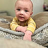 Kendall is registered to the contest to win money with this photo: baby, infant, child, face, eyes, hands, yellow_clothing, striped, cushion, pattern, indoor, soft, cozy, closeup, portrait, cute, young, person, skin, expression