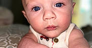 Kendall joined the competition — help win amazing prizes! baby, blue_eyes, chubby_arms, close_up, curious, expression, face, head, indoor, infant, pale_skin, patterned_blanket, portrait, reaching_out, resting_arms, skin_texture, soft_background, toddler, wearing_clothing, young_child