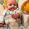 Kendall is registered to the contest to win money with this photo: baby, infant, child, onesie, toy, yellow, giraffe, monkey, animal_print, playful, smiling, indoor, soft_lighting, closeup, cute, seated, blanket, padded_seat, hand, face