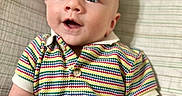 Kendall is registered to the contest to win money with this photo: baby, blue_eyes, child, close_up, colorful_clothing, cute, face, happy, indoors, infant, lying_down, milestone, plaid_blanket, portrait, short_hair, skin, smiling, striped_shirt, wooden_sign, young_child