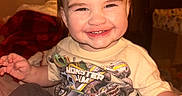 Sebastian joined the competition — help win amazing prizes! baby, casual, child, clothing, cozy, cute, cute_face, expression, face, hair, happy, indoor, monster_truck, person, playful, sitting, smile, toddler, tshirt, warm_lighting
