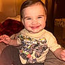 toddler, smile, child, indoor, happy, clothing, tshirt, monster_truck, person, cute, hair, face, sitting, cozy, warm_lighting, baby, expression, cute_face, casual, playful