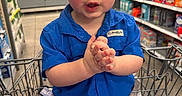 Sebastian joined the competition — help win amazing prizes! toddler, child, shopping_cart, blue_shirt, grocery_store, aisle, clothing, face, hands, expression, indoor, retail, sitting, cute, young_child, person, casual, shorts, toy, shopping