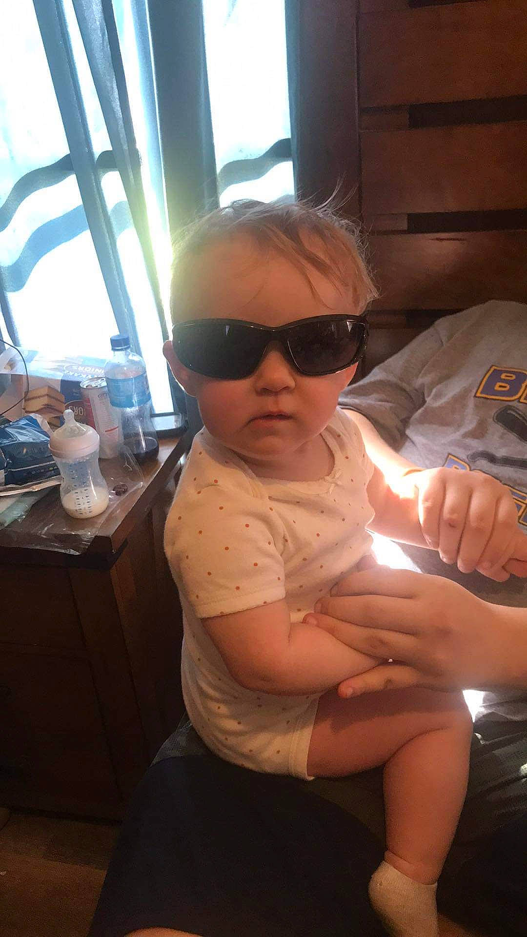 Kinzlee is registered to the contest to win money with this photo: baby, child, chin, comfort, elbow, eyewear, fun, goggles, human_leg, knee, lap, neck, person, personal_protective_equipment, sitting, skin, sunglasses, thigh, toddler, trunk