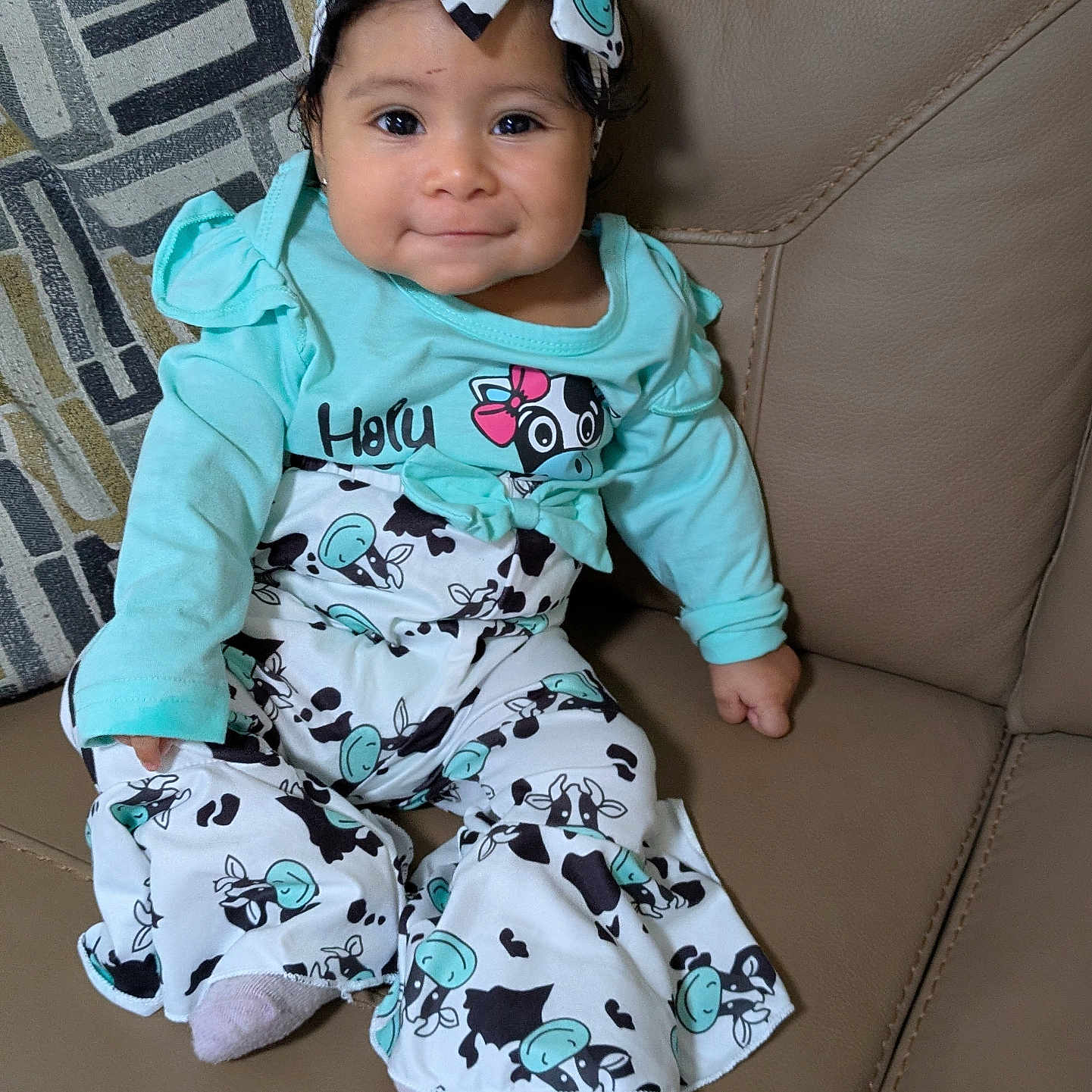 Rosaisela joined the competition — help win amazing prizes! baby, blue_clothing, child, couch, cow_print, cozy, cute, happy, headband, indoors, infant, leather, long_sleeve, patterned_pants, person, portrait, sitting, small_child, smiling, young_child