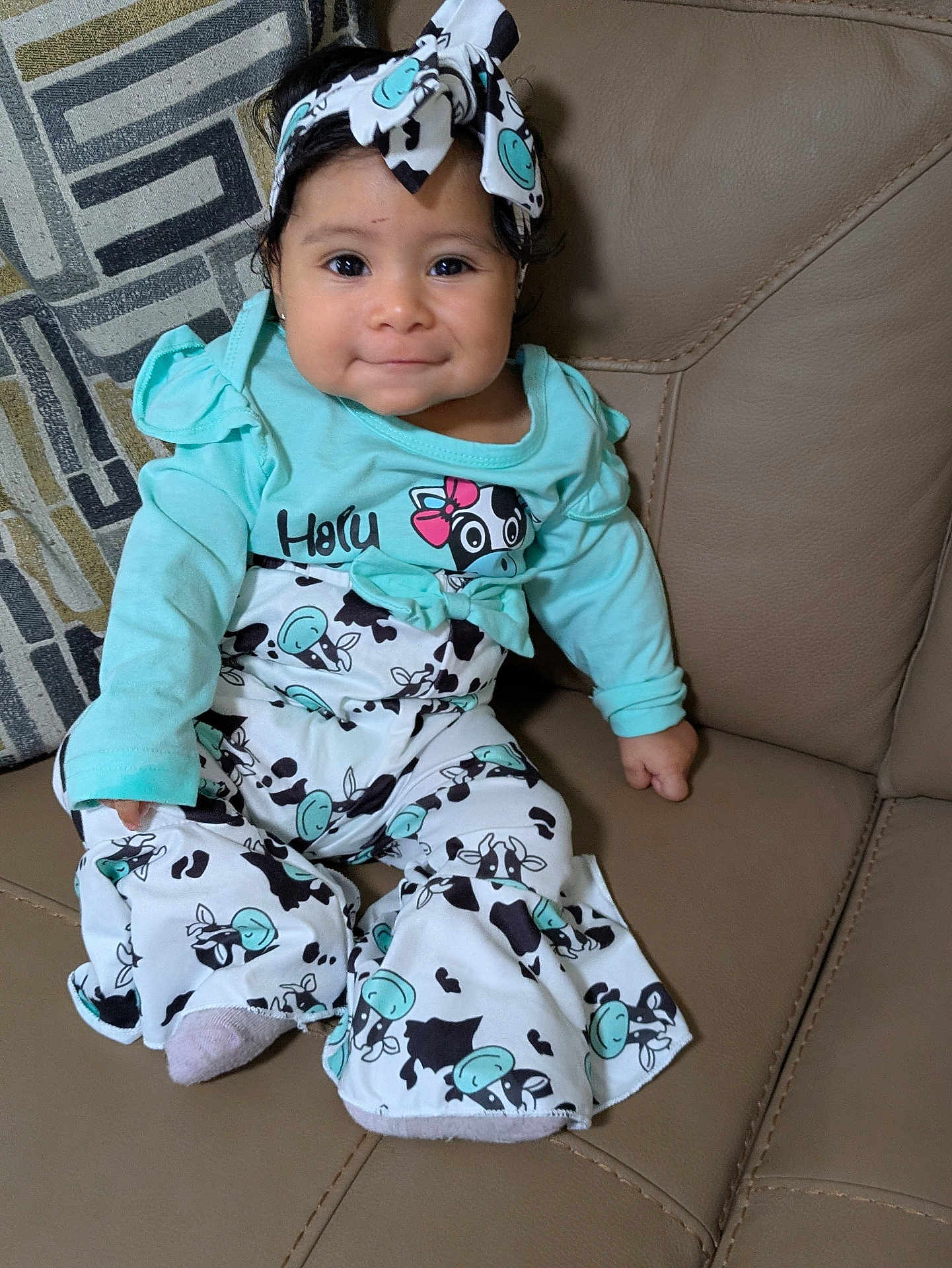 Rosaisela joined the competition — help win amazing prizes! baby, blue_clothing, child, couch, cow_print, cozy, cute, happy, headband, indoors, infant, leather, long_sleeve, patterned_pants, person, portrait, sitting, small_child, smiling, young_child