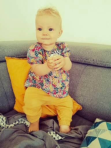 Juliette participe au concours pour gagner de l'argent avec cette photo : baby, baby_toddler_clothing, child, comfort, cool, couch, eye, finger, fun, hairstyle, happy, head, human_leg, lap, leg, person, skin, sleeve, smile, thigh