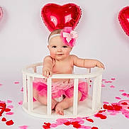 Gracie joined the competition — help win amazing prizes! baby, child, tutu, headband, pink, balloon, heart_shaped, rose_petals, white_background, cute, smiling, sitting, wooden_enclosure, infant, studio_photo, valentines_day, decorations, pose, happy, celebration