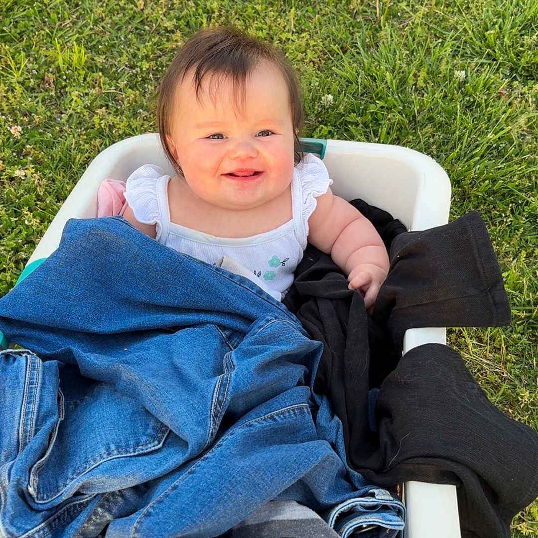 Iris is registered to the contest to win money with this photo: baby, clothing, coat, face, footwear, glove, grass, head, jacket, jeans, lawn, nature, outdoors, pants, park, person, photography, plant, portrait, shoe