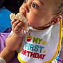 baby, child, birthday, bib, rice_cake, eating, socks, purple_blanket, closeup, curious, cute, infant, indoor, portrait, hand, face, skin, young, celebration, candid