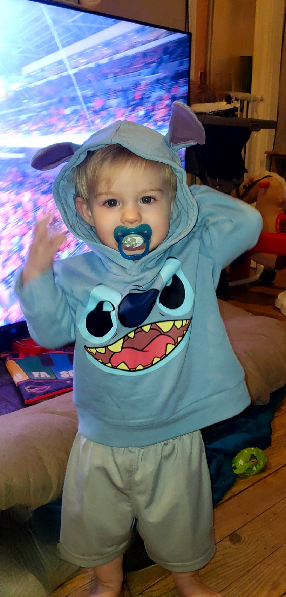 Leland is registered to the contest to win money with this photo: baby, baby_toddler_clothing, chair, child, cool, costume, fashion_accessory, fictional_character, fun, happy, hat, mouth, person, purple, room, shelf, sitting, sleeve, smile, t_shirt