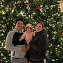 baby, celebration, child, christmas_tree, decorations, family, father, festive, happy, holiday, hoodie, indoor, lights, mother, ornaments, parent, portrait, smiling, togetherness, winter_clothing