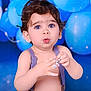 baby, balloons, blue_background, blue_eyes, celebration, child, closeup, cream, curly_hair, cute, expression, fun, hands, indoor, person, portrait, skin, surprised, suspenders, toddler