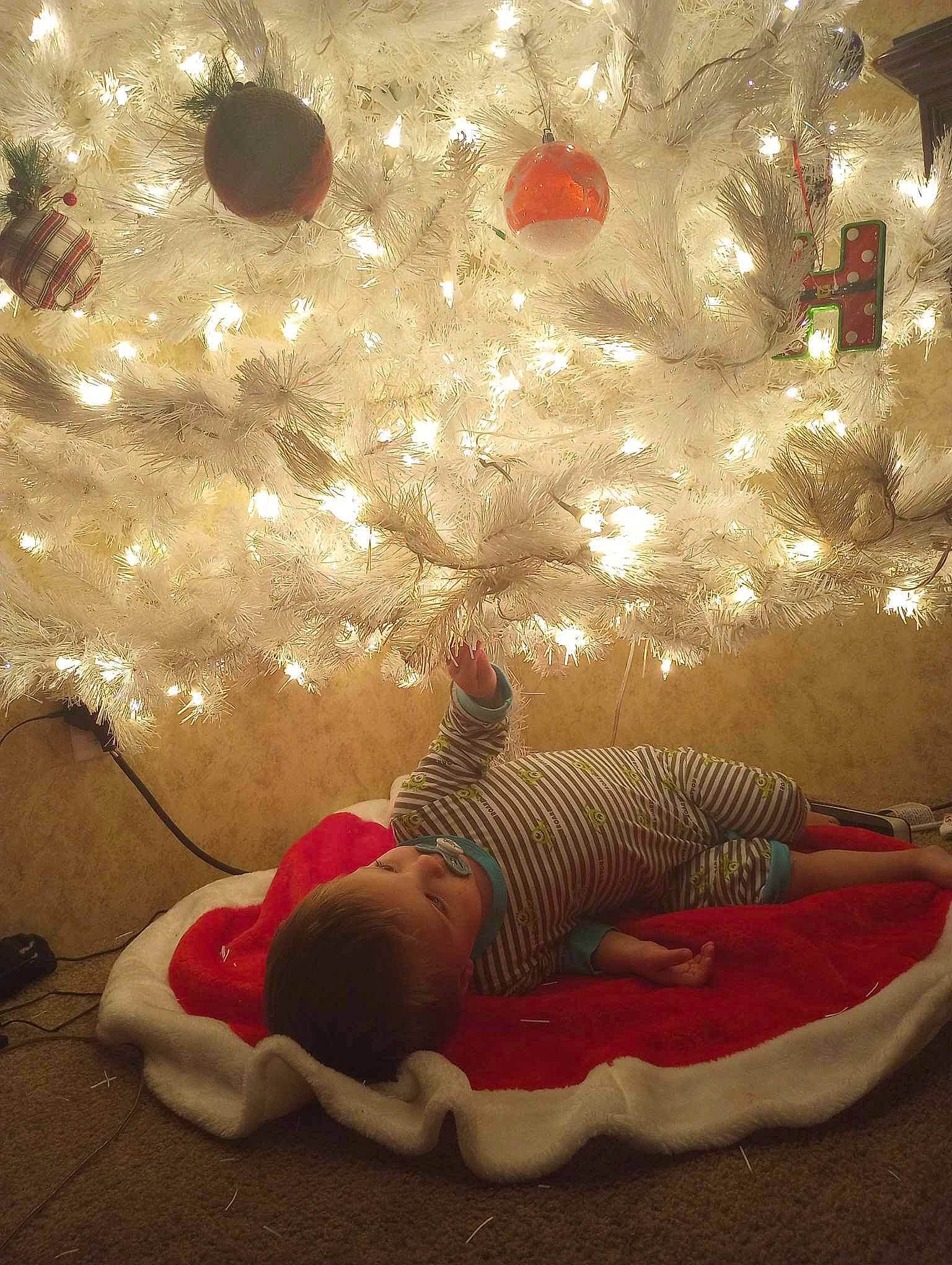 Zeke is registered to the contest to win money with this photo: baby, christmas, christmas_decoration, christmas_eve, christmas_ornament, christmas_tree, comfort, conifer, decoration, event, happy, holiday, holiday_ornament, interior_design, ornament, person, textile, toddler, tree, winter