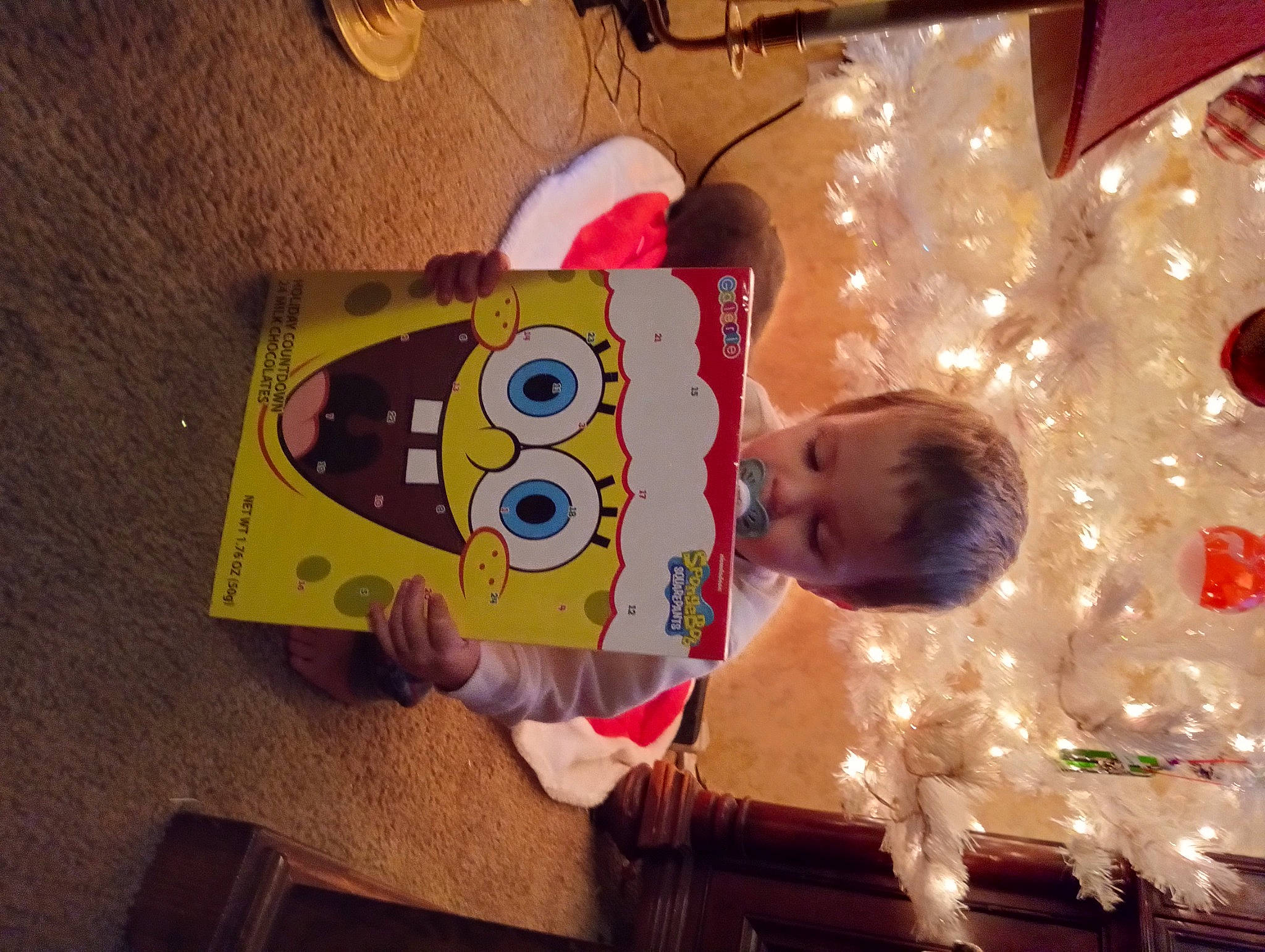 Zeke is registered to the contest to win money with this photo: art, baby, baby_toys, carmine, child, christmas_decoration, christmas_eve, christmas_ornament, christmas_tree, event, fun, happy, holiday, holiday_ornament, ornament, person, room, toddler, toy, tradition