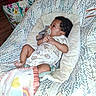 baby, baby_seat, baby_toy, blanket, child, clothing, colorful, comfort, cute, fabric, home, indoor, infant, pacifier, pattern, portrait, resting, shopping_bag, wood_floor, young_child