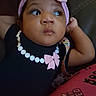 Charity joined the competition — help win amazing prizes! arm, baby, black_clothing, child, closeup, colorful_fabric, cute, face, gazing, headband, indoor, infant, patterned_clothing, pearl_necklace_print, person, pink_bow, portrait, resting, sitting, young_child